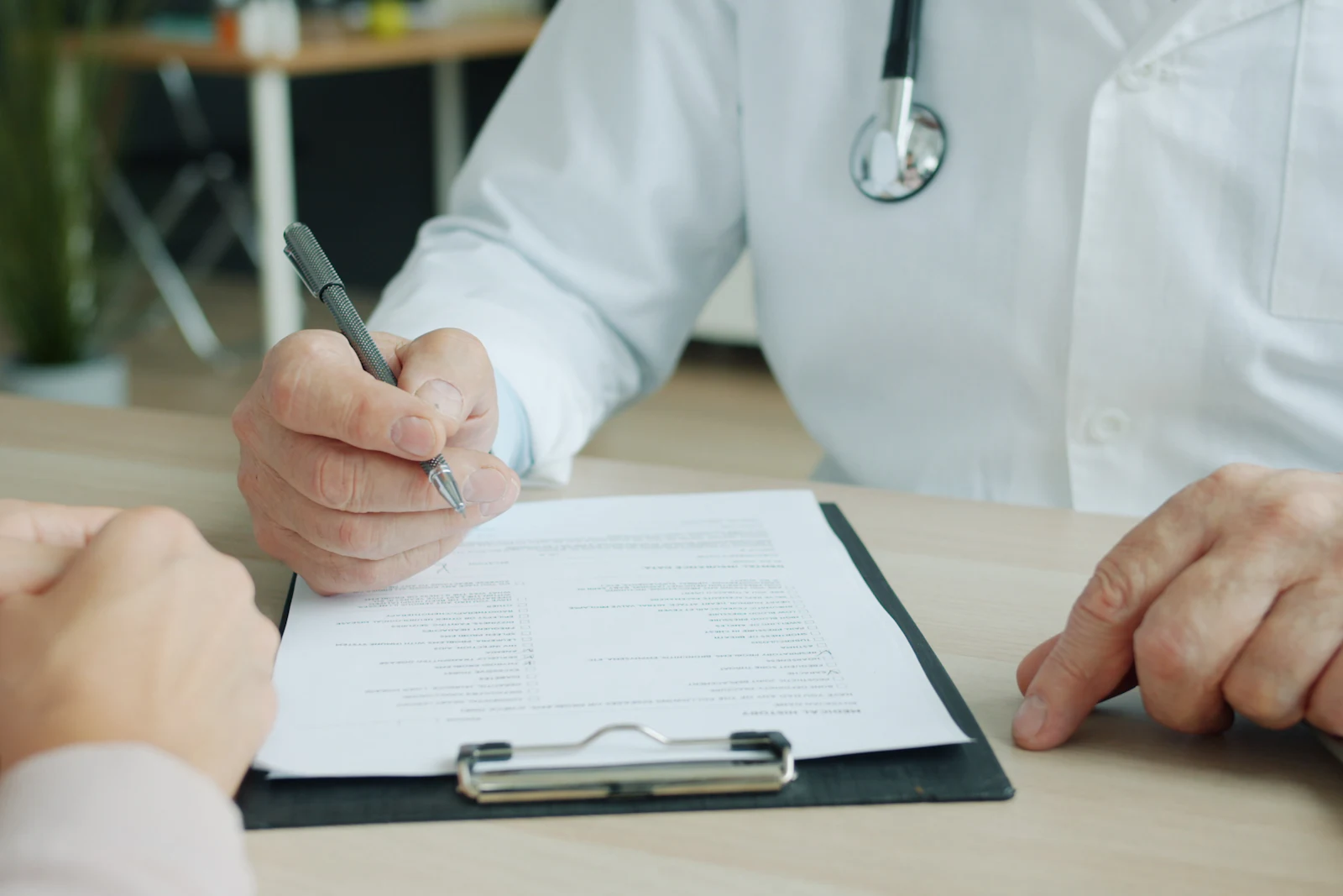 A clinician writing confidential notes on a clipboard