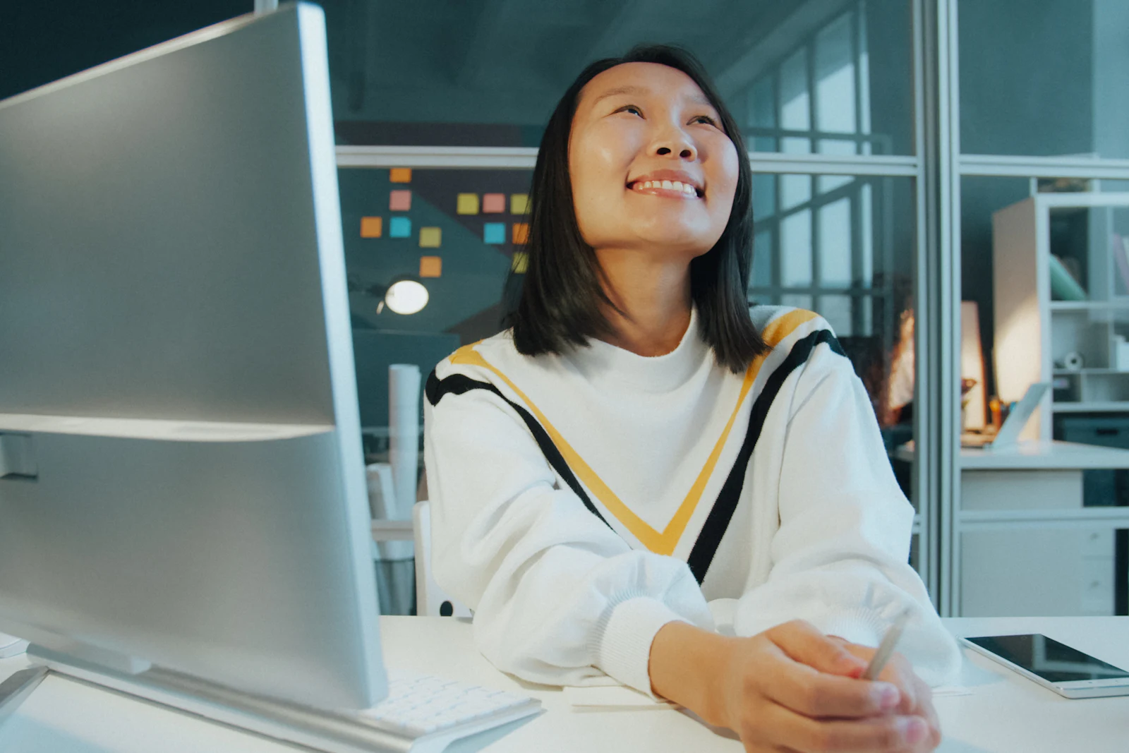 A smiling young professional at her desk in a bright office